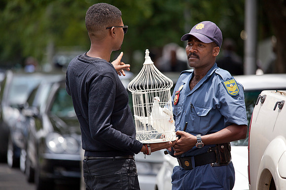 Man asks permission to release a dove outside Mandela's home, Houghton, 05.12.13.
