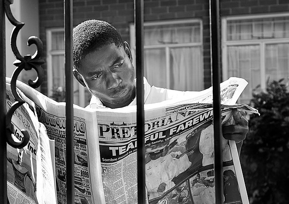 Pretoria News, man reads the details of Mandela's funeral, Pretoria, 11.12.13